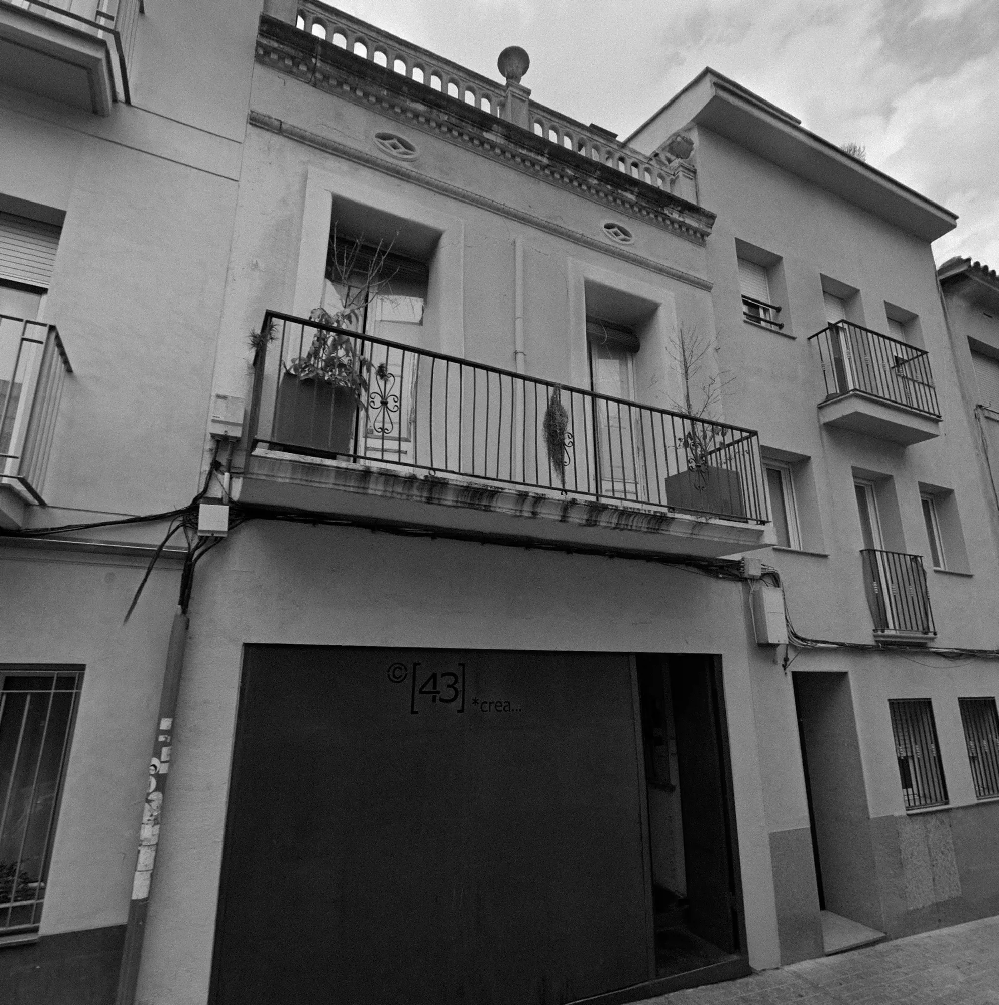 Façana de la finca del Camí Fondo, 11, amb el rètol de C43Crea damunt de la porta.